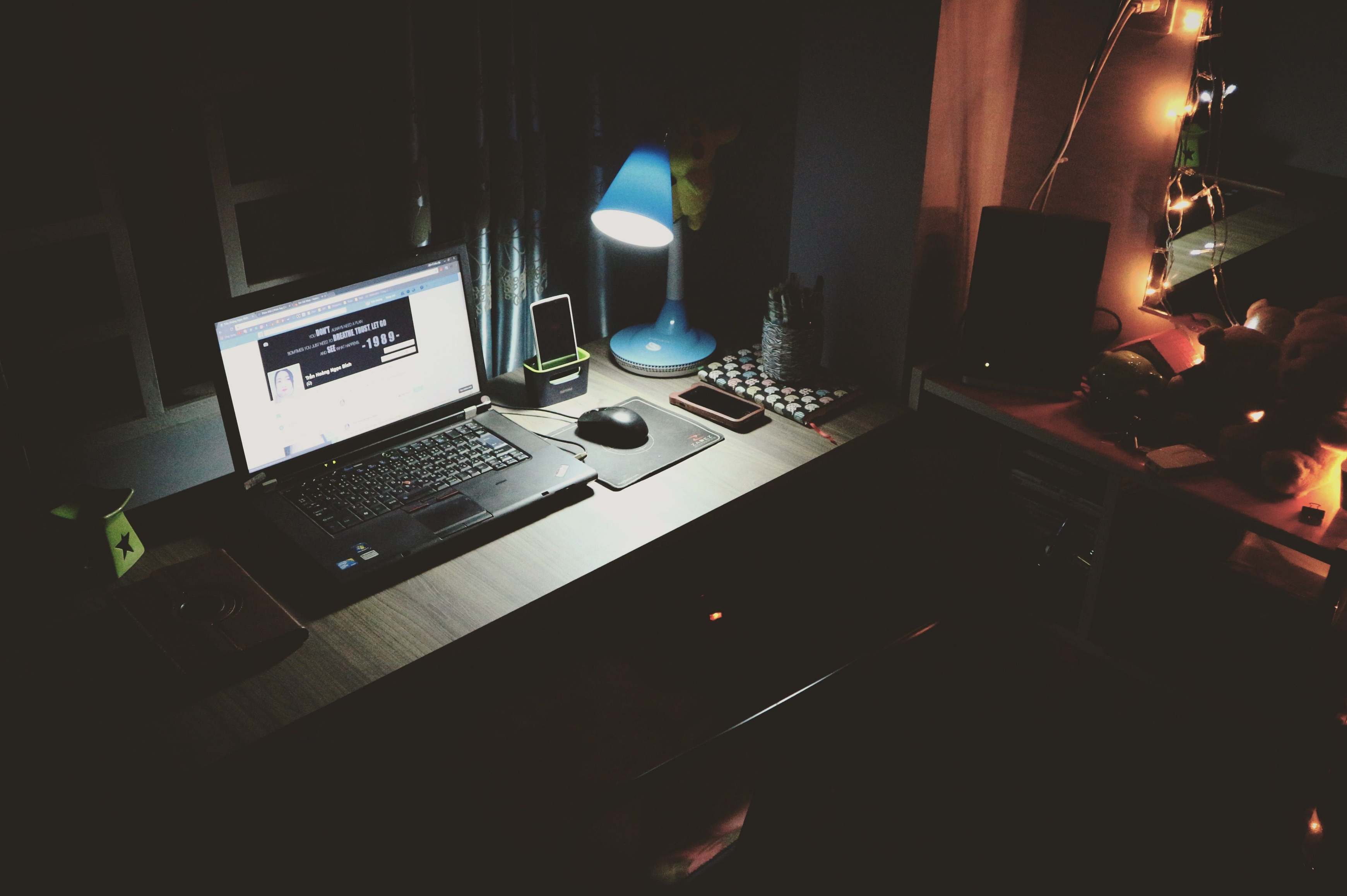 Arbeitsplatz mit Laptop und Notizen bei abendlicher Beleuchtung